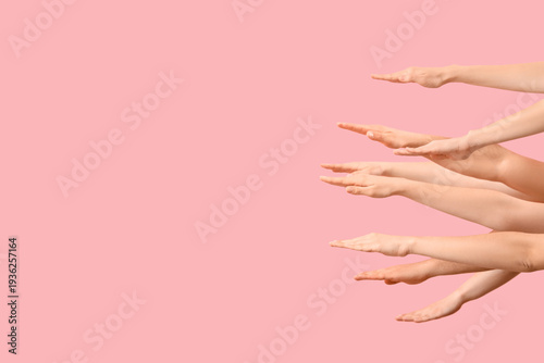 Many hands on pink background