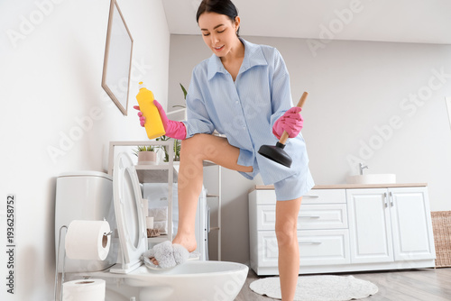 Young woman with plunger an...