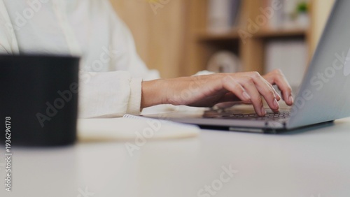 Fotografía Close-up of Asian woman's hands typing on laptop keyboard
