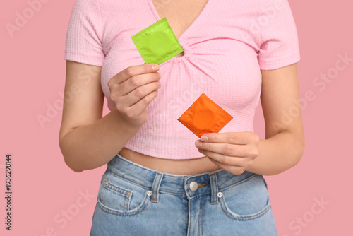 Woman holding condoms on pi...