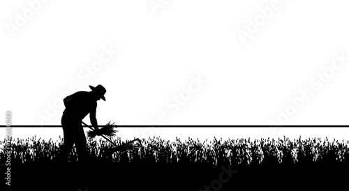 Farmer silhouette harvesting crops in a field at sunrise.