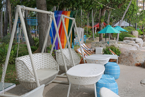 Canvas Print White wicker swing chairs and blue stools offer a perfect spot for relaxation at a colorful beachfront resort