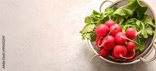 Colanders of fresh radish on light background with space for text