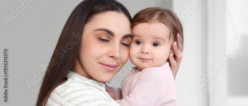 Young mother hugging her ba...