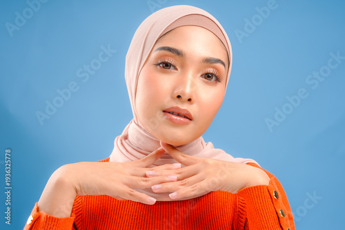 Schilderij op canvas Beautiful young Asian Muslim woman wearing hijab with make up posing and looking to the camera