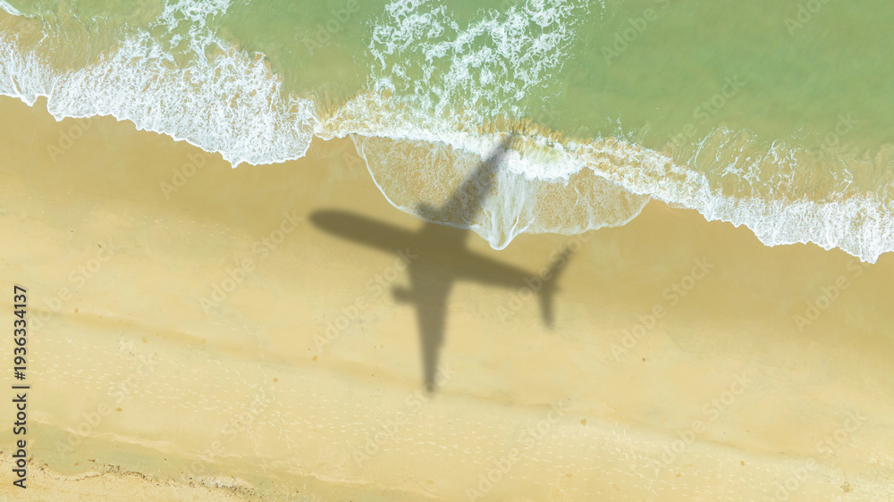 Fototapeta premium Aerial view of shadow passenger plane silhouette and sandy beach blue sea with waves at sea beach summer vacation sea travel concept 