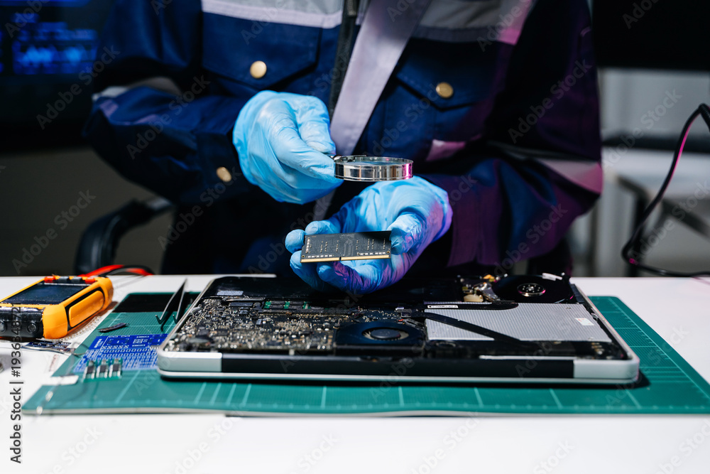 Naklejka premium Technician wearing protective gloves installing RAM memory on laptop motherboard, symbolizing computer repair, hardware upgrade, electronics engineering