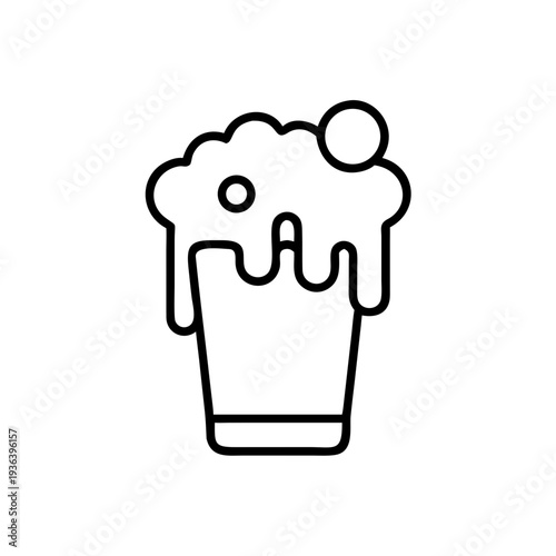 Foam beer overflowing from a glass with bubbles on top  