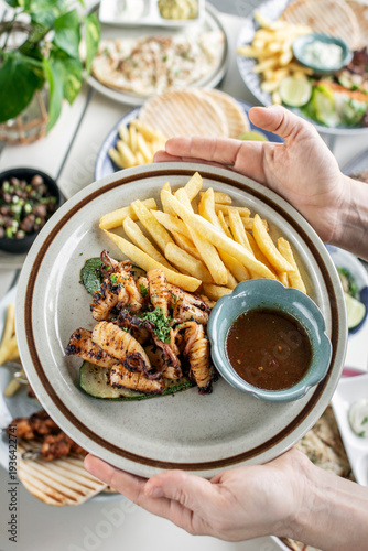 Wallpaper Mural mediterranean style grilled squid with escabeche sauce and fries on white table at ibiza spain restaurant Torontodigital.ca