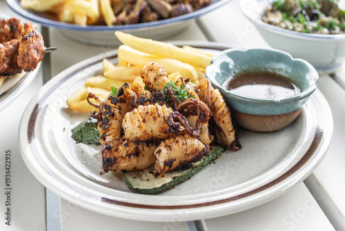 Wallpaper Mural mediterranean style grilled squid with escabeche sauce and fries on white table at ibiza spain restaurant Torontodigital.ca