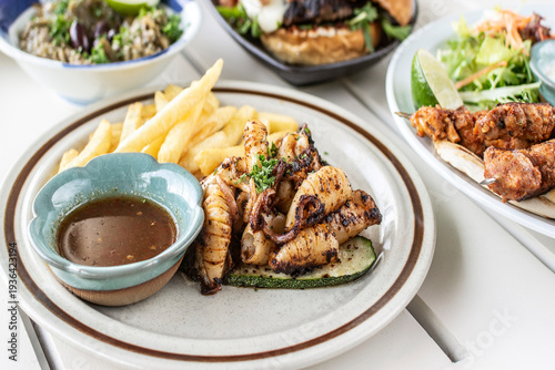 Wallpaper Mural mediterranean style grilled squid with escabeche sauce and fries on white table at ibiza spain restaurant Torontodigital.ca