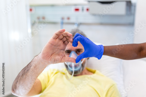 Wallpaper Mural Healthcare and Medicine. Close up of a doctor and patient making a heart shape with their hands. A mature man with an oxygen mask and a medical professional in blue gloves showing hope and support. Torontodigital.ca