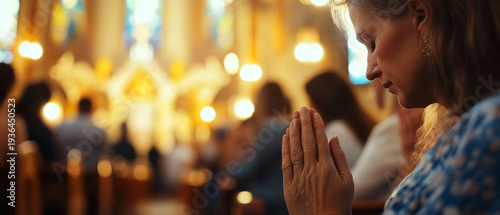 A woman deeply engaged in prayer inside a warmly lit church, surrounded by other worshippers, conveying devotion