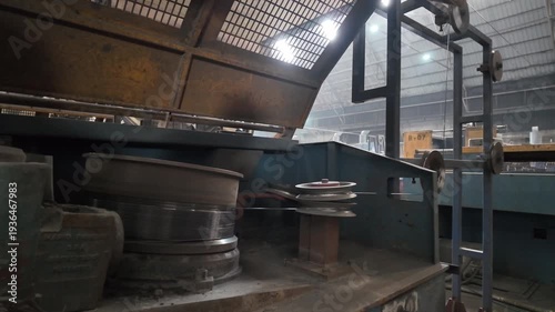 Reinforcing steel bars are rotating in a reducing machine to be cut into wire in an industrial plant.