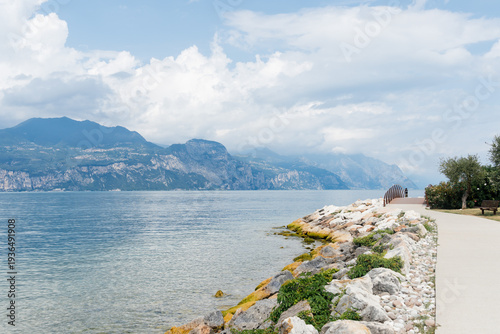 Wallpaper Mural Scenic view of Lake Garda with mountains and a pathway along the shore. Torontodigital.ca