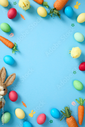 Easter frame with colorful eggs, carrots, chicks and bunny on blue background