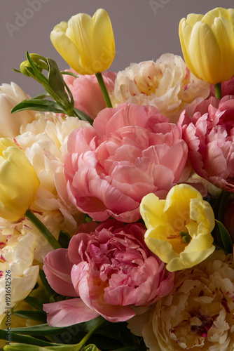 Pink and yellow floral arrangement with blooming peonies and tulips embodying spring and celebration