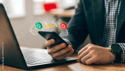 Man sitting at desk with laptop and smartphone in hand with social media icons floating above