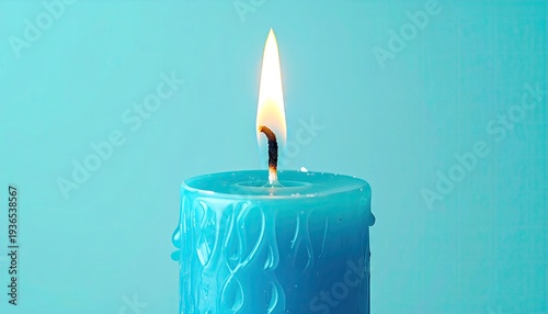 Burning blue candle with dripping wax on light blue surface