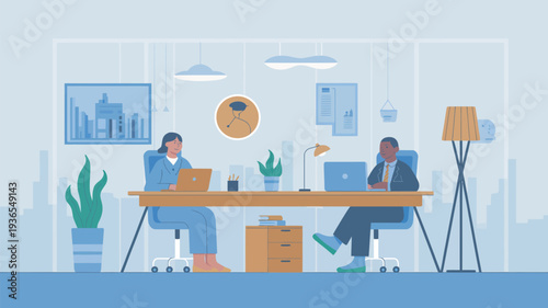 Two professionals working together at a large desk in a modern office space with laptops and plants