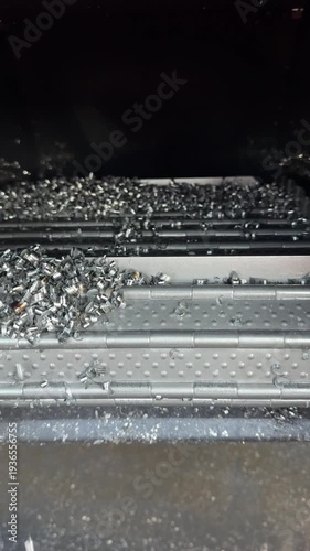 Chip conveyor feeds metal chips away from milling machine, transporting shavings efficiently to collection tray for automated cleanup and safety.