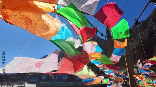 Slow-motion view of Tibetan prayer flags fluttering in the wind, symbolizing spirituality, peace, and traditional culture in a serene outdoor setting.