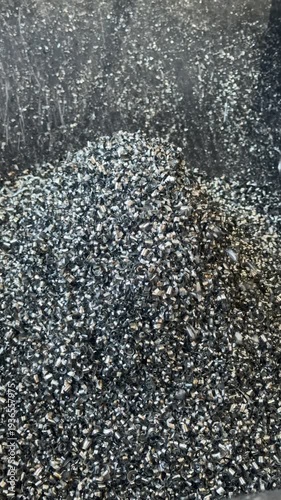Metal chips cascade into the chip tray of a metalworking machine during machining, collecting waste for efficient cleanup and safety.
