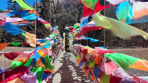 Slow-motion view of Tibetan prayer flags fluttering in the wind, symbolizing spirituality, peace, and traditional culture in a serene outdoor setting.