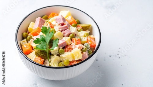 Colorful olivier salad in a bowl on white background vibrant potato carrot pea ham appetizing lunch dish for catering.