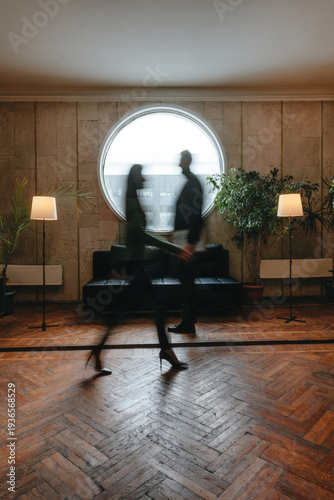 Businesspeople walking in stylish office interior with motion blur