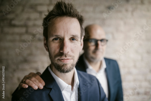 Portrait of senior businessman behind and mid-adult businessman