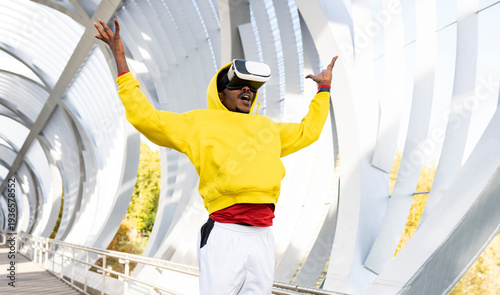 Carefree sportsman using virtual reality headset while standing on walkway