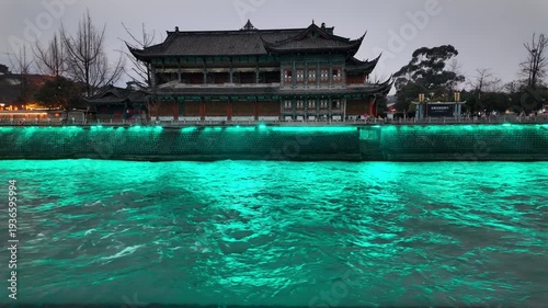 Scenic view of Dujiangyan River with the historic Nanqiao Bridge, featuring traditional Chinese architecture and a vibrant cultural landscape in Sichuan, China.