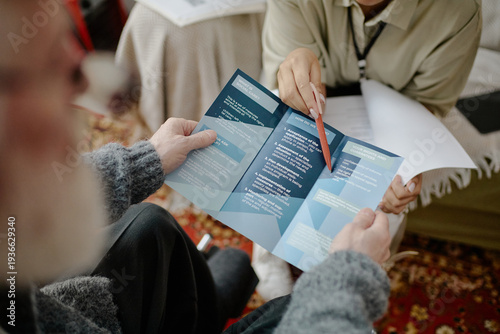 Schilderij op canvas Caucasian man in wheelchair receiving informational brochure from young adult Bl