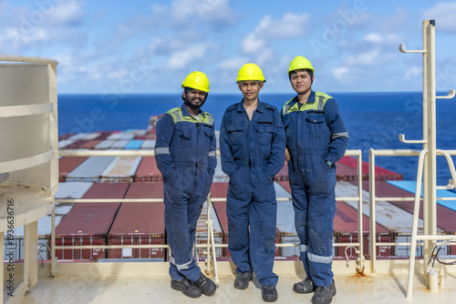 Фотография Maritime professionals standing on the upper deck near satellite equipment, taking a brief pause while at sea