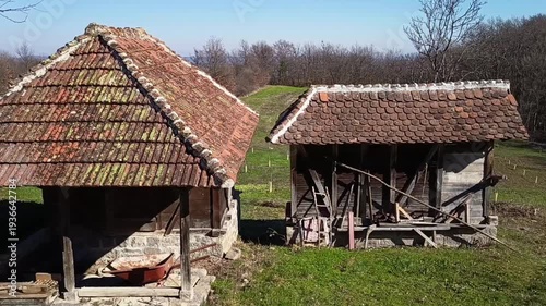 Old rustic farm sheds with clay tile roofs in peaceful rural countryside landscape