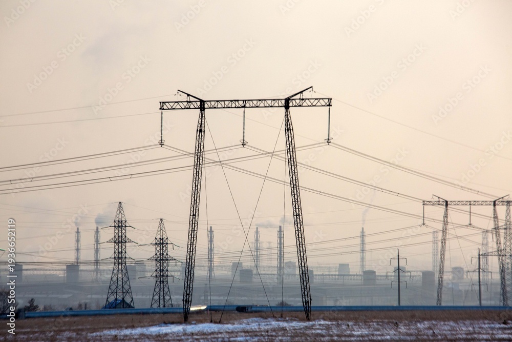 Fototapeta premium Industrial landscape with power transmission towers and lines. Environmental issues.
