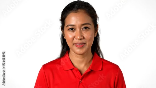smiling young woman wearing a red polo shirt looking directly at the camera with a neutral background
