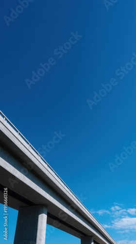 Perspective View of a Tall Concrete Highway Overpass Against a Clear Blue Sky