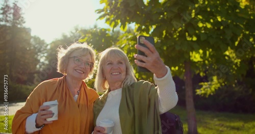Senior women friends taking a selfie in a sunny park