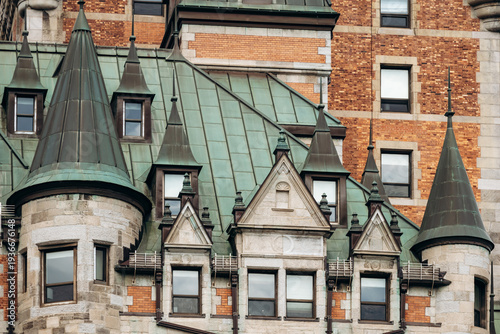 Quebec City, Canada - August 23, 2025: Close-up architectural details of Fairmont Le Chateau Frontenac hotel towers, green copper roofs, turrets and brick stone facade elements