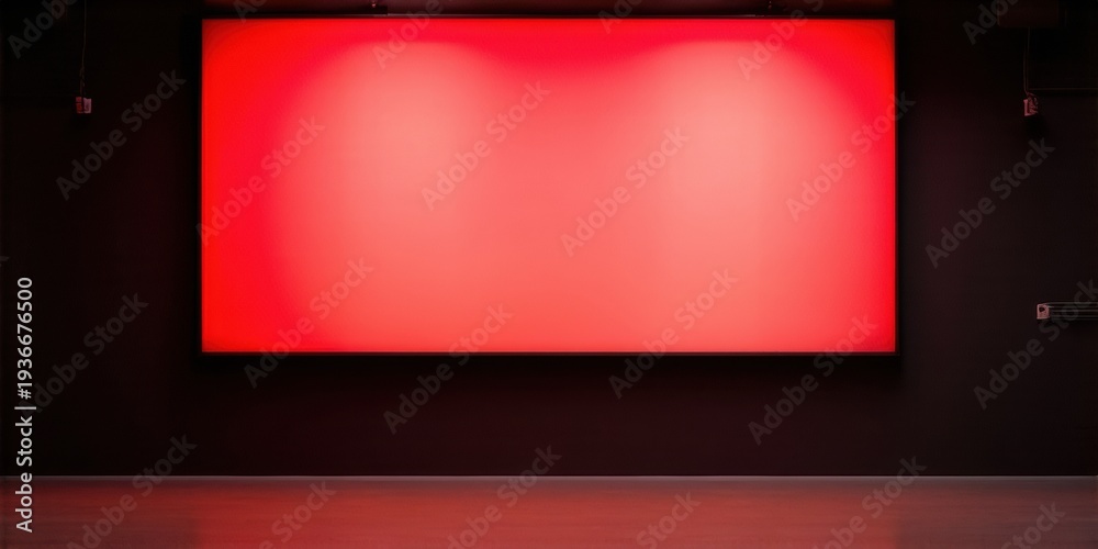 Fototapeta premium Empty cinema screen glows red. Dark room, minimal lighting, stage presentation. Dramatic effect, focus on blankness.