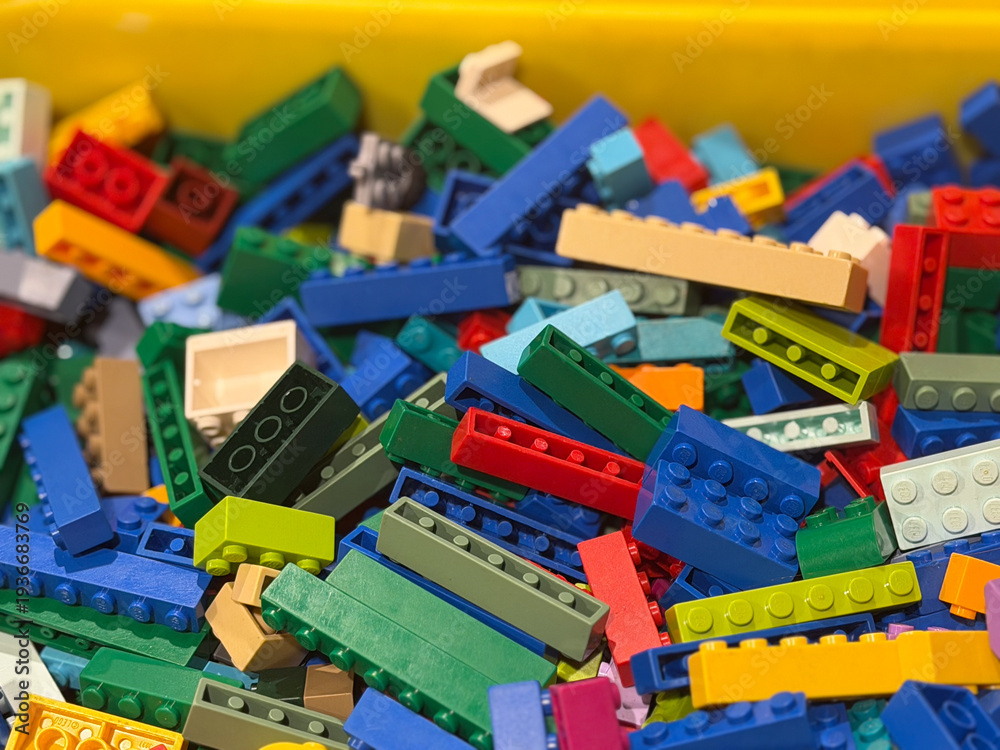 Fototapeta premium Colorful plastic building bricks in a bin