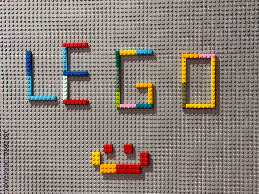 Fototapeta premium Lego letters and smiley on gray baseplate