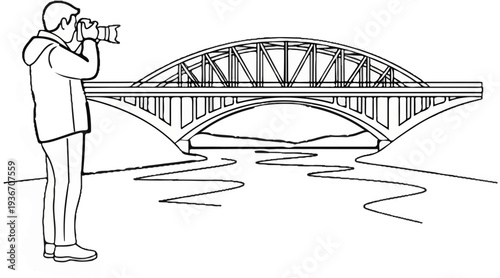A photographer takes a picture of a large bridge spanning a winding river