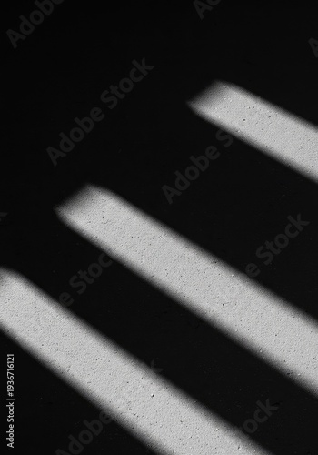 Minimalist abstract background featuring dramatic interplay of natural light and sharp geometric shadows across a textured surface, sharp, shape, bright