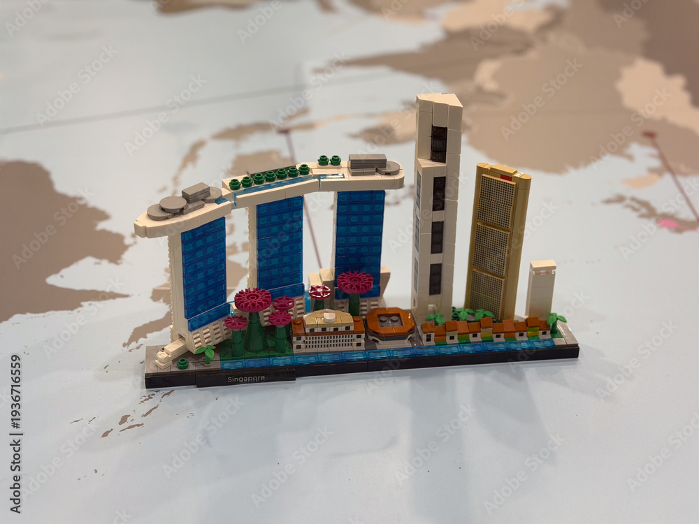 Fototapeta premium Toy brick miniature skyline on world map background