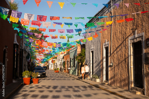Colorful papel picado flags adorn a charming street in Valladolid, Mexico