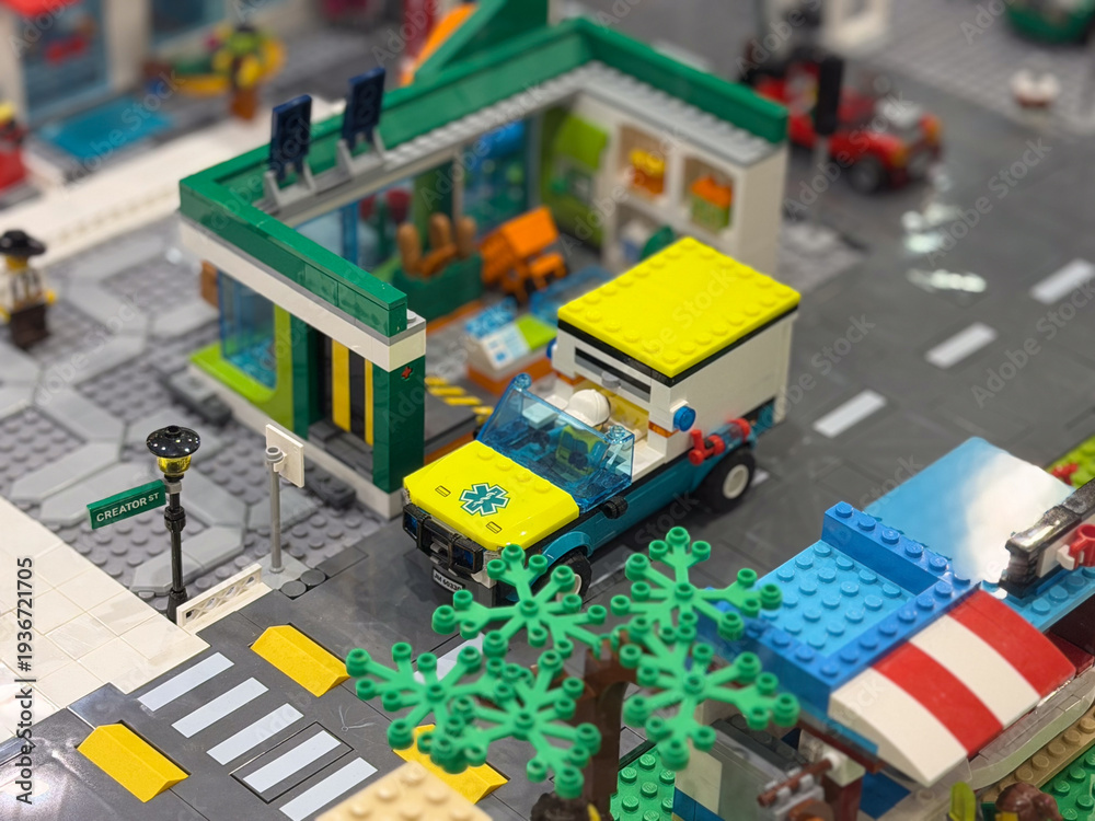 Fototapeta premium Lego ambulance by green-roofed building