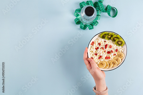 Healthy breakfast bowl with cottage cheese, fresh kiwi, banana slices and dried strawberries
